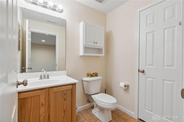 half bathroom featuring vanity, toilet, baseboards, and visible vents