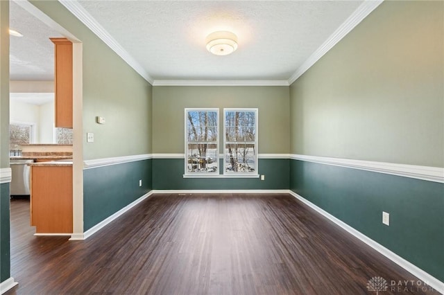 spare room featuring baseboards, a textured ceiling, dark wood-style floors, and ornamental molding