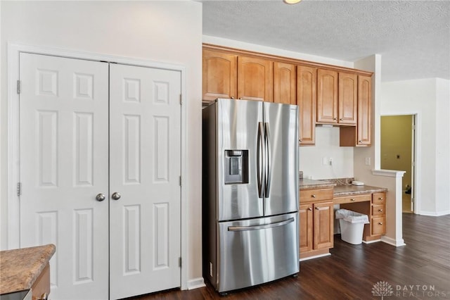 kitchen with a textured ceiling, stainless steel fridge with ice dispenser, light countertops, baseboards, and dark wood-style flooring