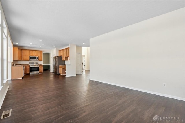 unfurnished living room featuring dark wood-type flooring, recessed lighting, baseboards, and visible vents