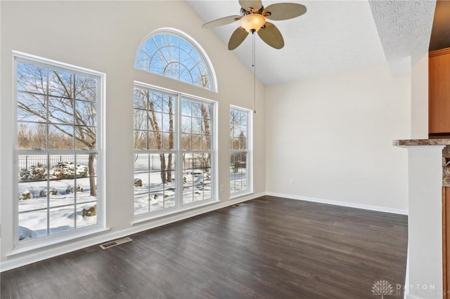 interior space featuring visible vents, baseboards, ceiling fan, dark wood-style floors, and high vaulted ceiling