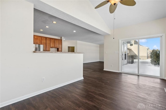 unfurnished living room with baseboards, lofted ceiling, a ceiling fan, and dark wood-style flooring