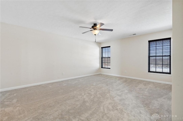 carpeted empty room with baseboards, a textured ceiling, and ceiling fan