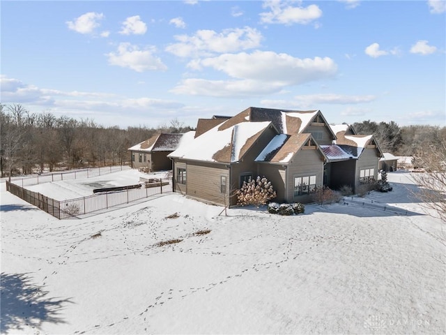 snow covered property with fence