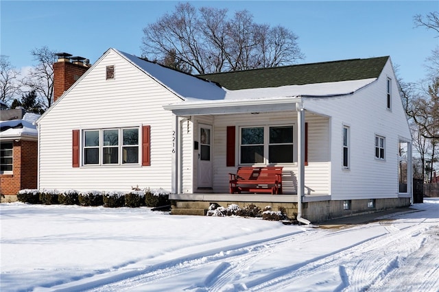 bungalow with covered porch and a chimney