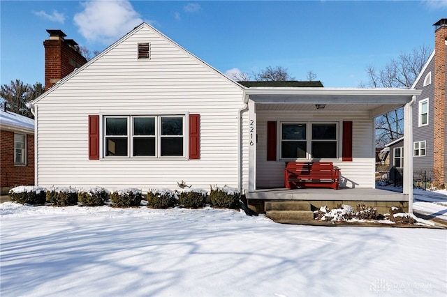 bungalow with covered porch and a chimney