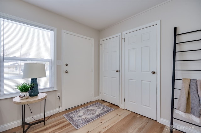 entrance foyer with baseboards and light wood-style floors