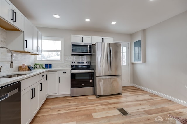 kitchen featuring stainless steel appliances, white cabinetry, and a sink