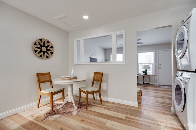 interior space with baseboards, light wood-type flooring, and stacked washer / drying machine