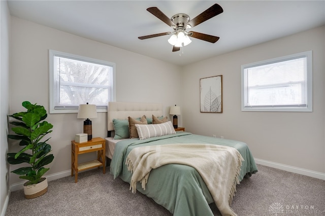 bedroom with carpet flooring, ceiling fan, baseboards, and multiple windows