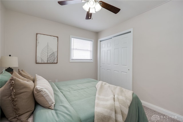 carpeted bedroom with ceiling fan, a closet, and baseboards