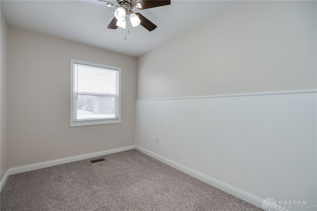 carpeted empty room with ceiling fan, visible vents, and baseboards