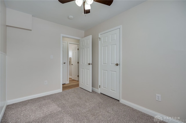 unfurnished bedroom with light carpet, ceiling fan, and baseboards