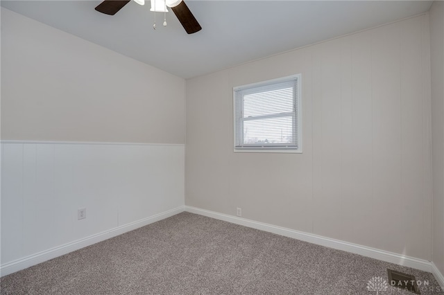 spare room featuring carpet floors, baseboards, and a ceiling fan