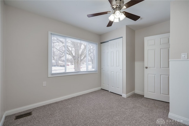 unfurnished bedroom featuring light carpet, baseboards, visible vents, ceiling fan, and a closet