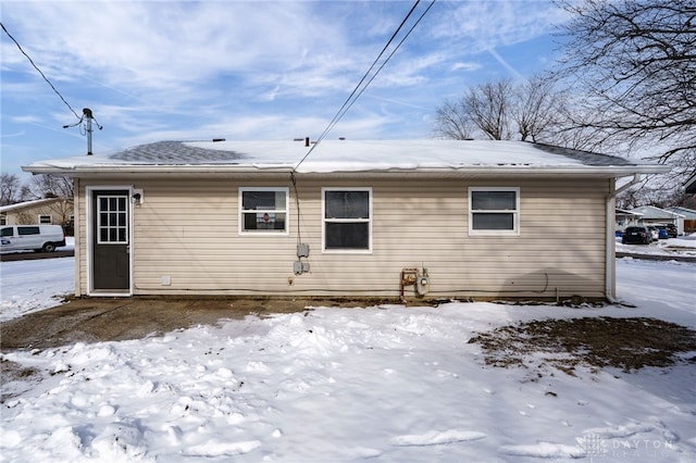 view of snow covered rear of property