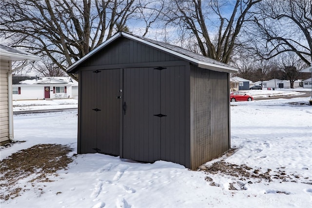 snow covered structure featuring a storage shed and an outdoor structure