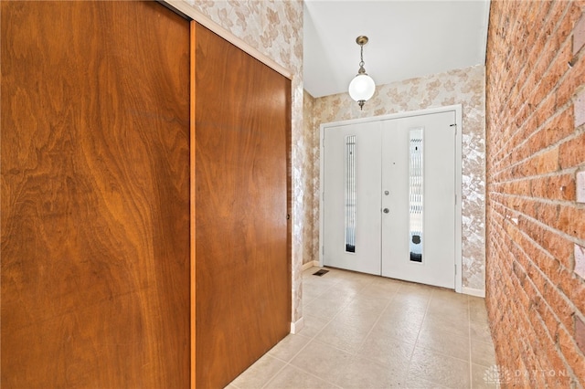 2242 E Rahn Rd, Dayton, OH 45440 - foyer with wallpapered walls, light tile patterned floors, and baseboards