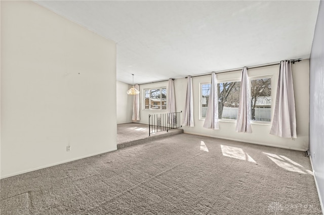 spare room featuring carpet floors and baseboards