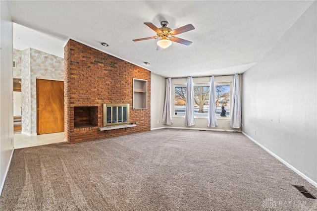 unfurnished living room with baseboards, a fireplace, visible vents, and carpet flooring