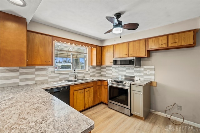 kitchen with stainless steel appliances, brown cabinets, light countertops, and a sink