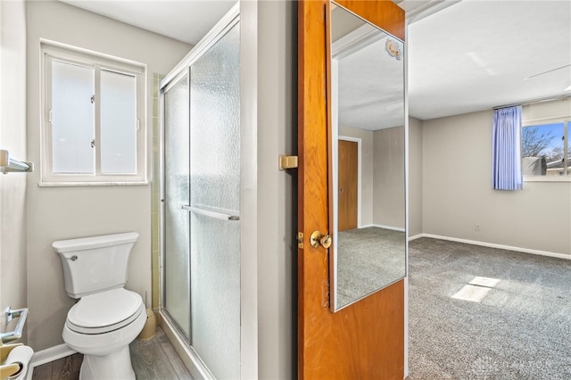 full bathroom featuring a stall shower, toilet, and baseboards