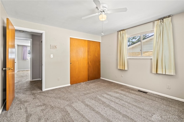 unfurnished bedroom featuring carpet floors, a closet, visible vents, ceiling fan, and baseboards