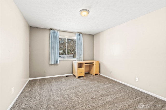 carpeted empty room featuring visible vents, a textured ceiling, and baseboards