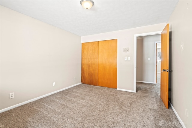 unfurnished bedroom featuring a closet, carpet, and baseboards