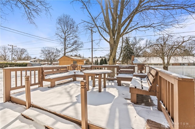 snow covered deck featuring fence