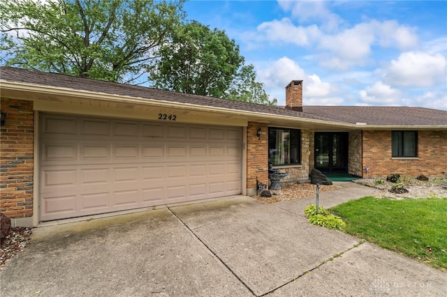 2242 E Rahn Rd, Dayton, OH 45440 - ranch-style house featuring a garage, concrete driveway, a chimney, and brick siding