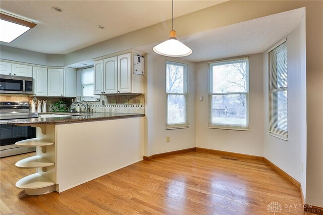 kitchen with white cabinets, pendant lighting, a peninsula, stainless steel appliances, and open shelves