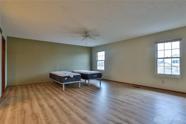 rec room featuring a ceiling fan, light wood-type flooring, visible vents, and baseboards