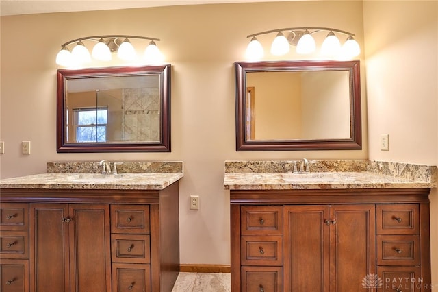 bathroom with a sink, baseboards, and two vanities