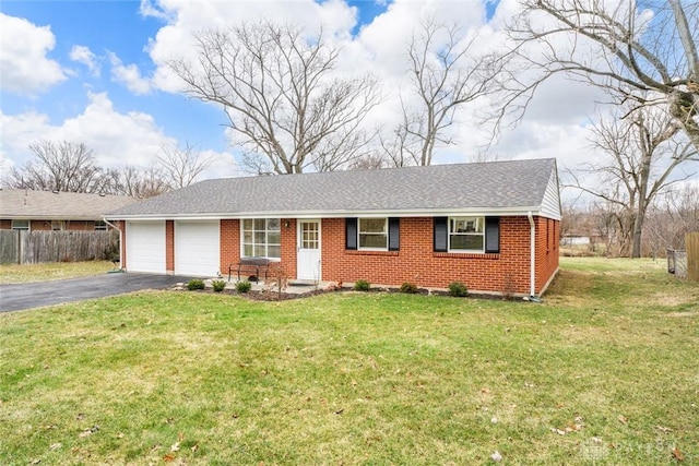 ranch-style house featuring brick siding, an attached garage, a front yard, fence, and driveway