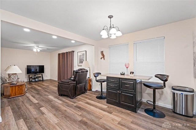 interior space with recessed lighting, light wood-style flooring, baseboards, and ceiling fan with notable chandelier