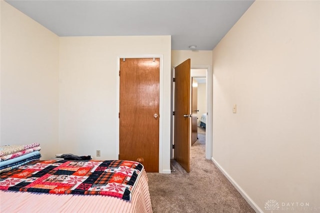 bedroom with light carpet and baseboards