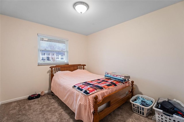 bedroom with dark colored carpet and baseboards