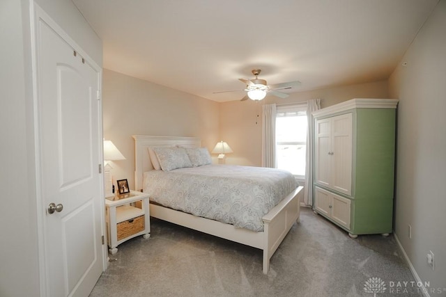 bedroom featuring light colored carpet, ceiling fan, and baseboards