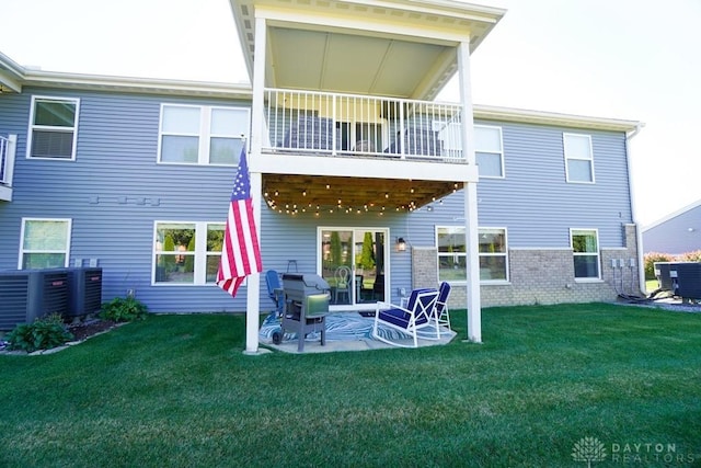 back of property featuring a patio, brick siding, a lawn, and central AC unit