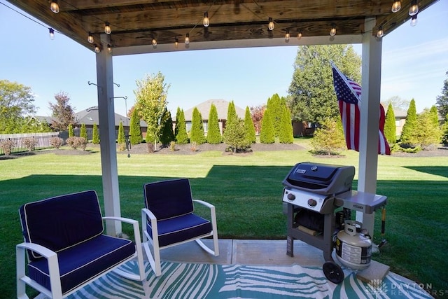 view of patio featuring a grill and fence