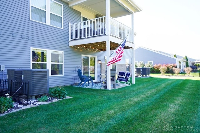 rear view of house with a patio, a yard, and central air condition unit