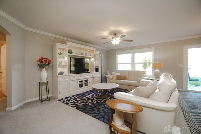 living room featuring a wealth of natural light, arched walkways, light carpet, and crown molding