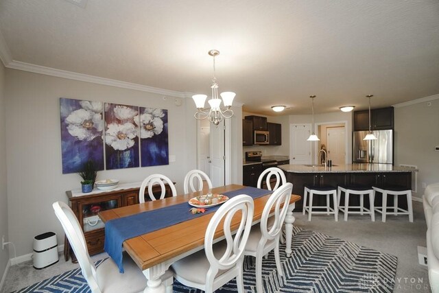 dining space featuring light carpet, an inviting chandelier, baseboards, and crown molding