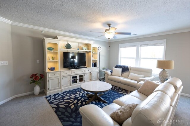 living area featuring a textured ceiling, carpet flooring, a ceiling fan, baseboards, and crown molding