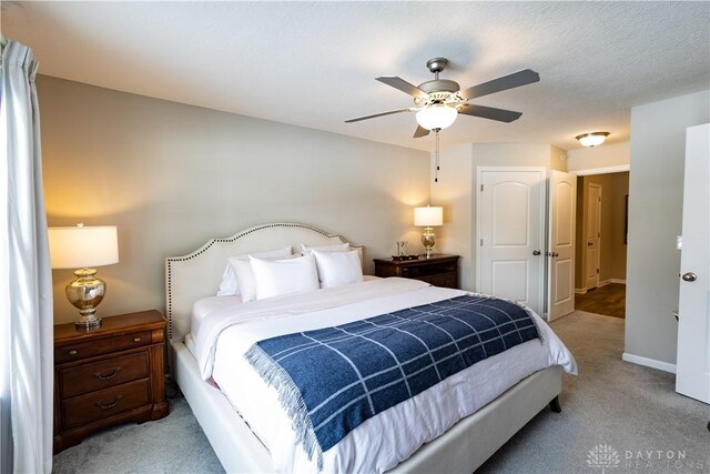 bedroom with light carpet, ceiling fan, and baseboards