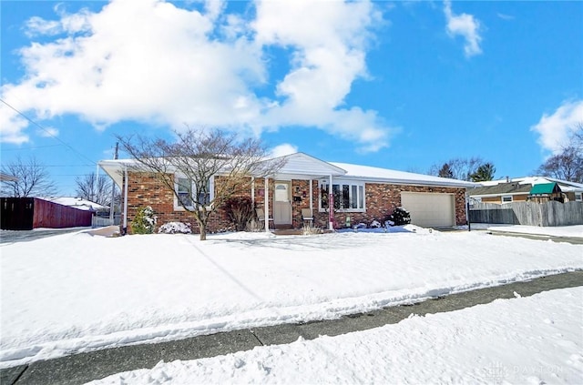 single story home with brick siding, an attached garage, and fence