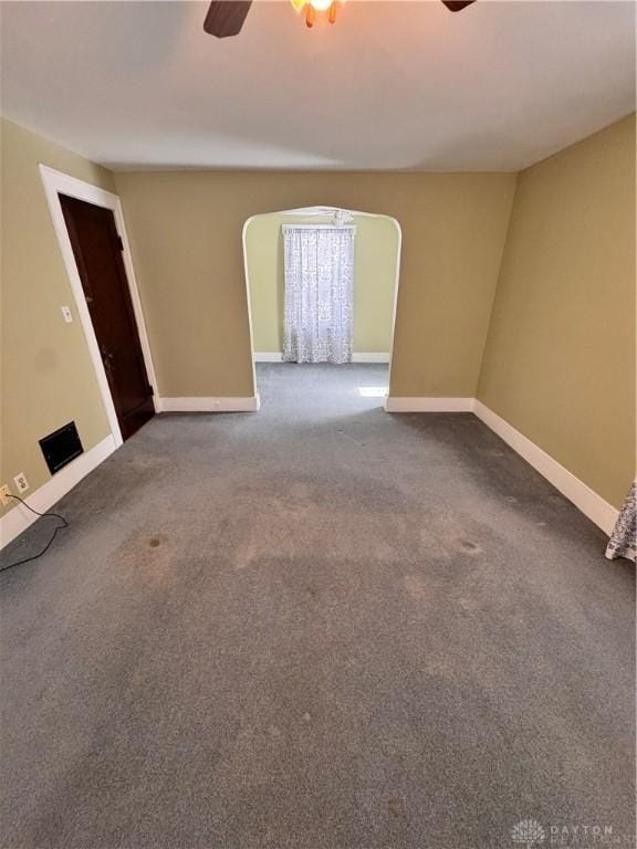 230 New Columbia Blvd, Sidney, OH 45365 - unfurnished living room featuring carpet floors, ceiling fan, baseboards, and arched walkways