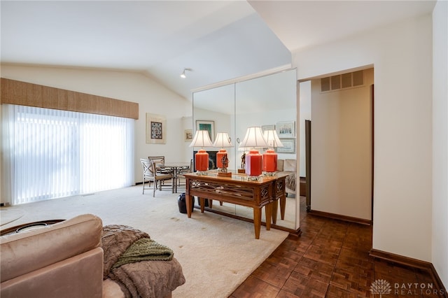 living area with lofted ceiling, visible vents, and baseboards