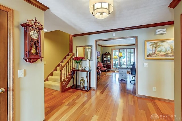 entrance foyer featuring baseboards, stairway, light wood-type flooring, and crown molding